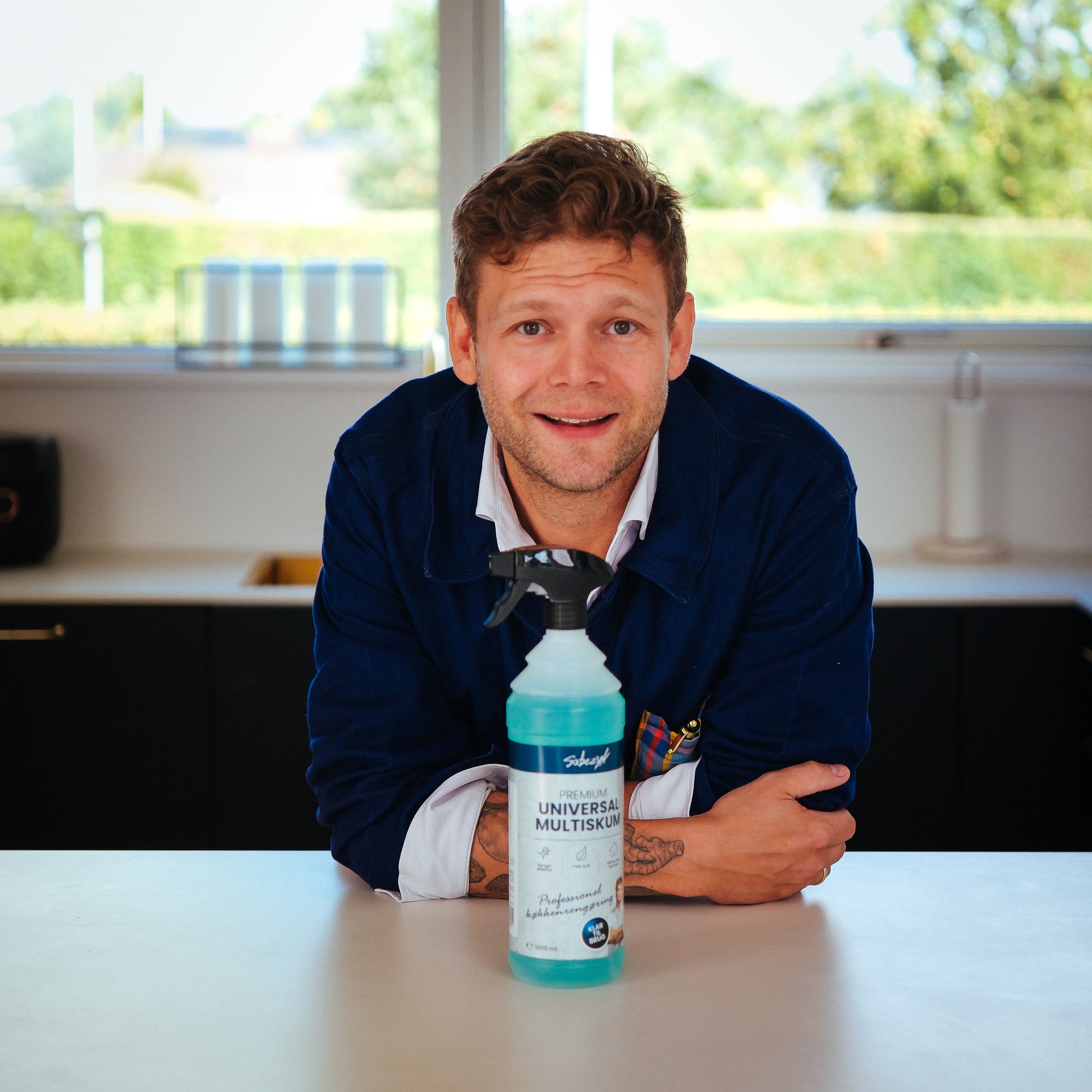 Casper Sobczyk med en flaske Sobczyk Premium Universal Multiskum 1000 ml i køkkenet